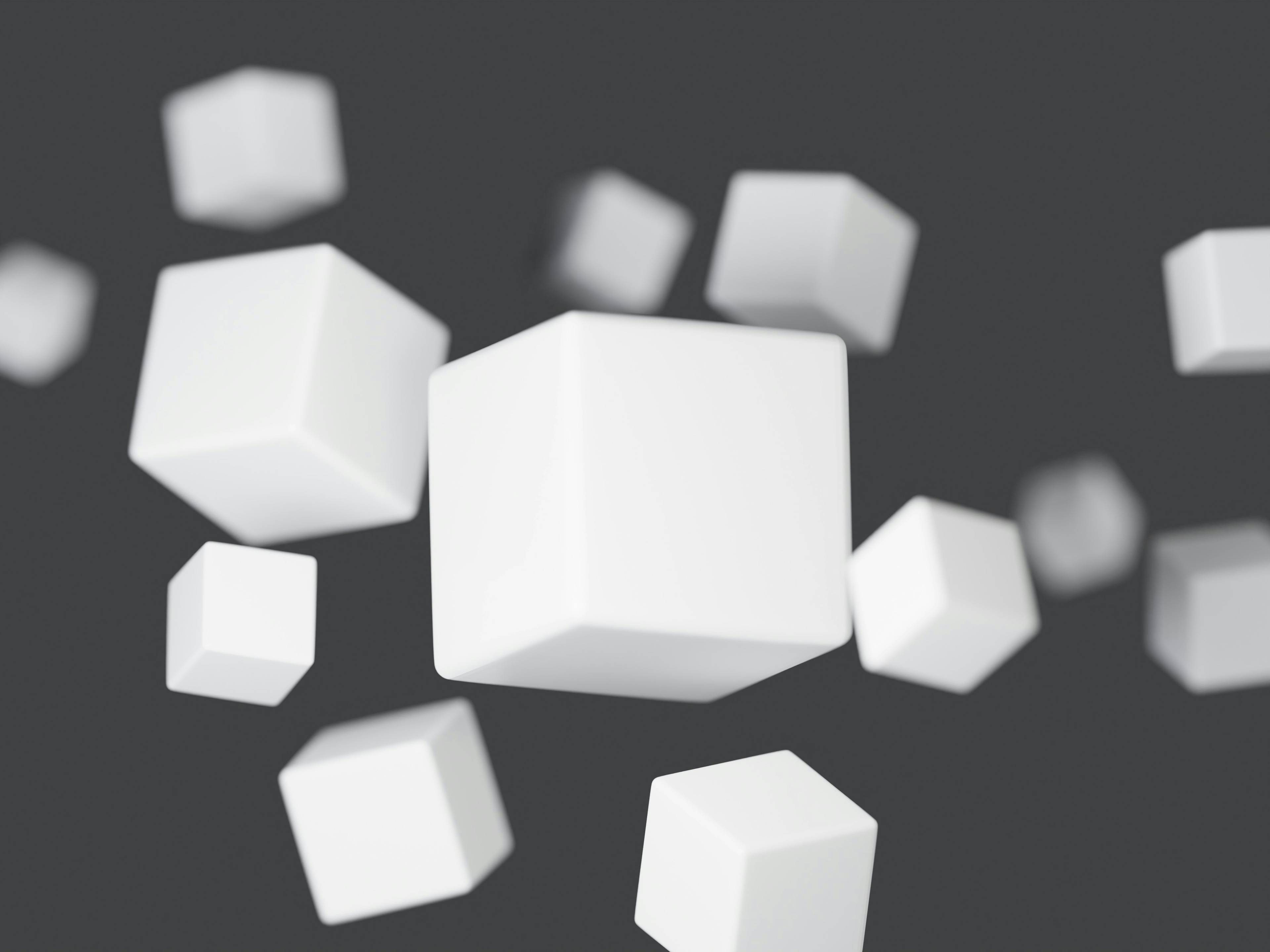 masantocreative-5f3-yga-www-unsplash-40fe0c17-3611-4d0a-aae0-803e957f27fc La imagen muestra varios cubos blancos flotando en un fondo gris.