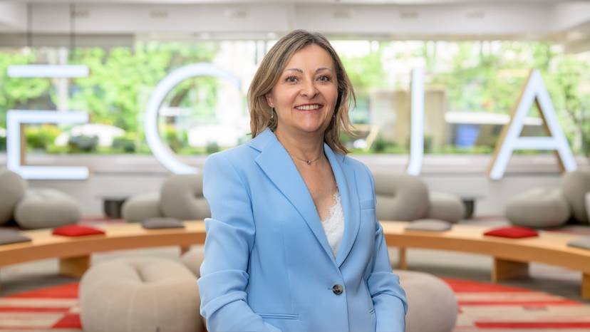 Cristina Rubio Una mujer sonriente con un blazer azul posando en un entorno moderno y luminoso.
