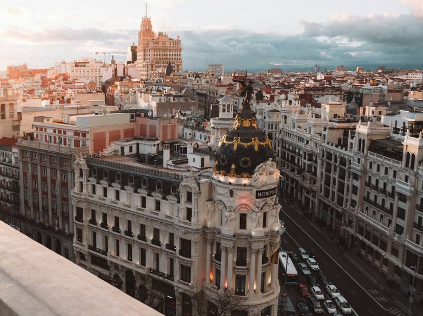 alex-azabache-fbyb7pgzasq-unsplash_1 Vista aérea del Edificio Metrópolis en Madrid durante el atardecer, destacando su cúpula dorada.