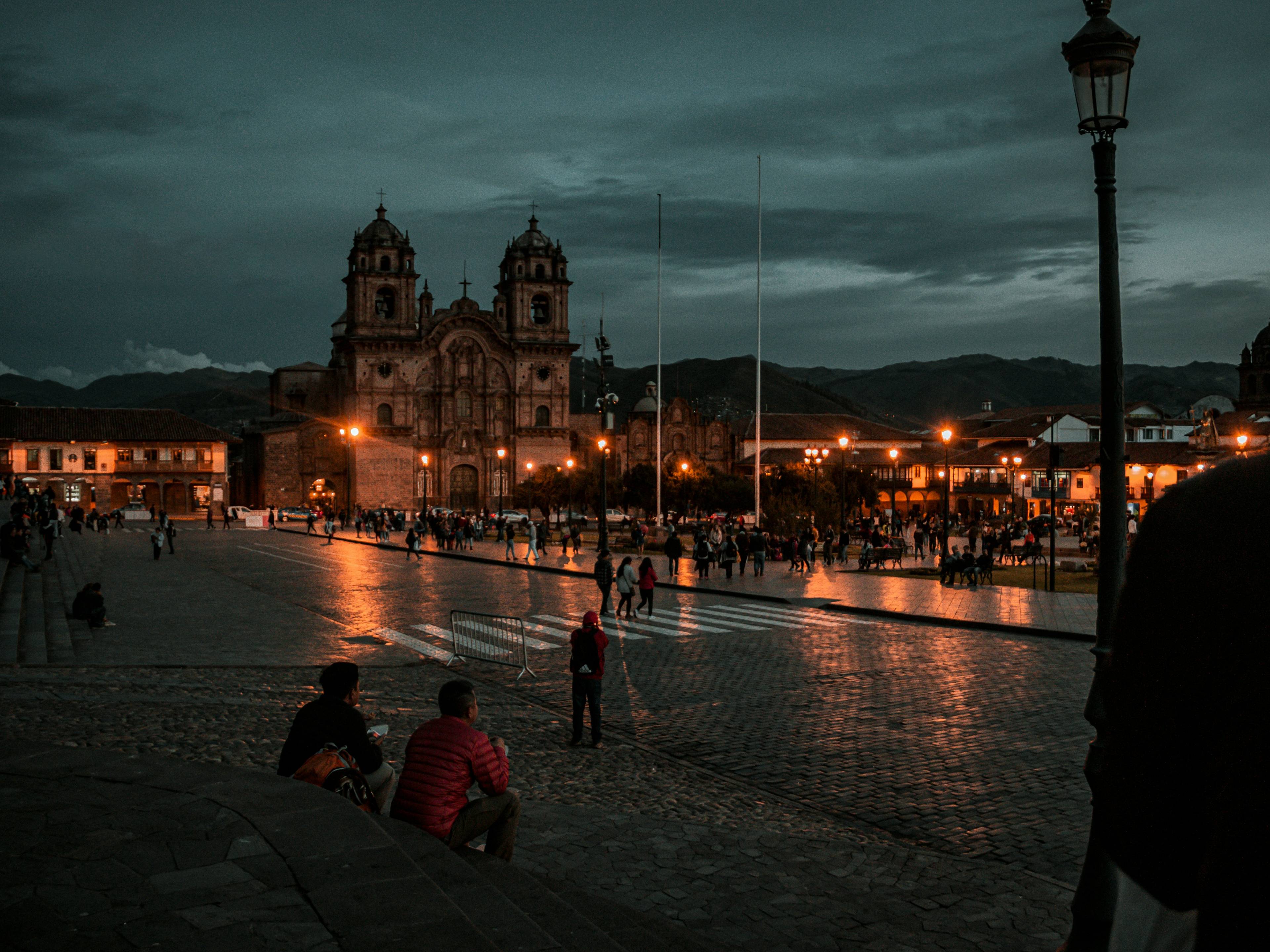Una plaza iluminada al atardecer con una hermosa arquitectura de fondo en Cusco, Perú.