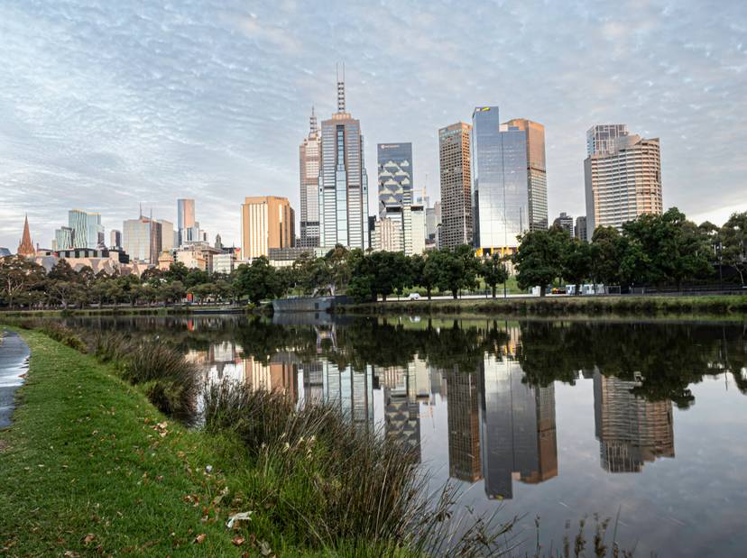Una vista del horizonte de Melbourne reflejado en el agua durante el amanecer.