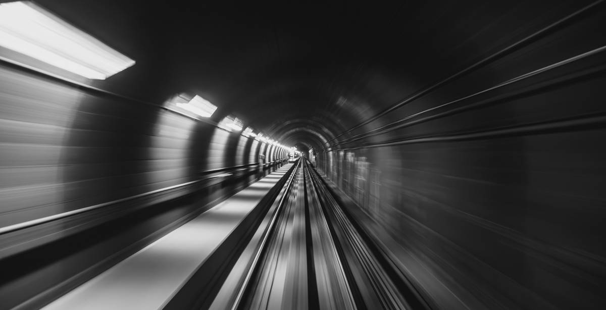 Una vista desenfocada del túnel de un tren en blanco y negro.