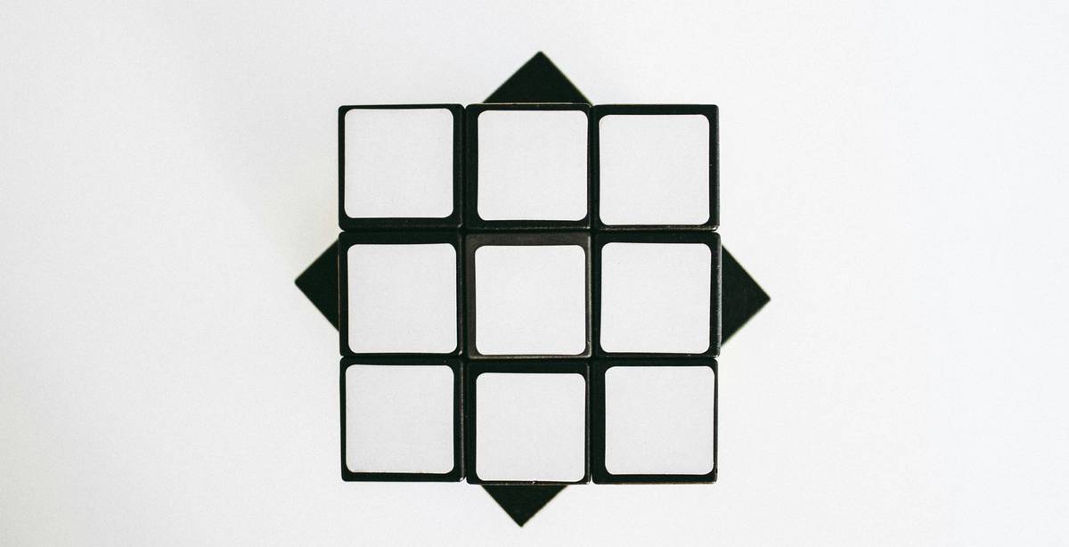 Una vista superior de un cubo de Rubik vacío y desarmado sobre un fondo blanco.
