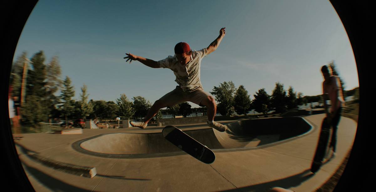 Un skater realiza un salto acrobático sobre un skate en un parque.