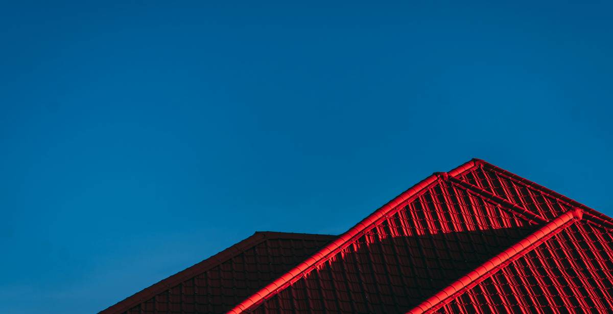 Una imagen de un tejado con luces rojas contra un cielo azul claro.