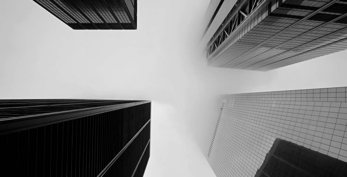 Una vista en ángulo de edificios altos bajo un cielo nublado.